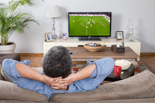 man watching football match at home